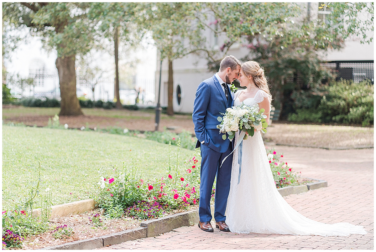 bride and groom pose with noses touching in Charleston park