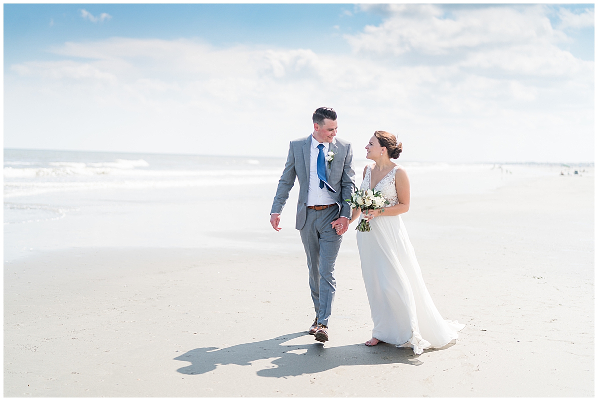 bride and groom walk on beach at Isle of Palms